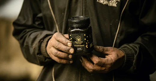 a person holding mad honey jar