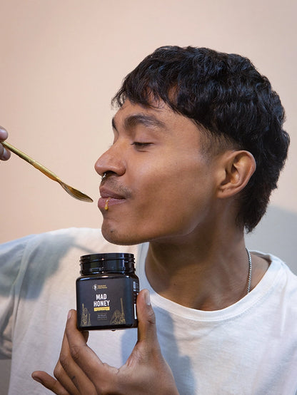 A boy tasting mad honey from Nepal and feeling happy